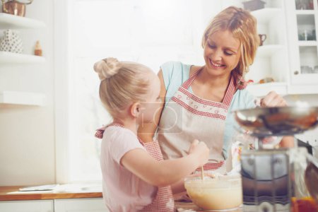 Photo for Teaching her all the tricks of baking. Cute little girl baking in the kitchen with her mom - Royalty Free Image