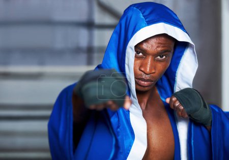 Téléchargez les photos : Mettez-les en place. Un boxeur afro-américain avec les poings levés et un regard déterminé dans les yeux - en image libre de droit