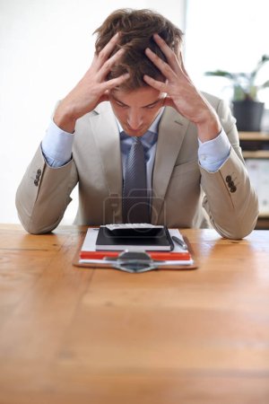 Foto de Sobrecarga del sistema... un joven empresario sentado en su escritorio con la cabeza en las manos - Imagen libre de derechos
