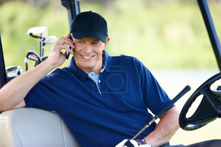 Téléchargez les photos : Devine ce que je fais en ce moment. un homme assis dans une voiturette de golf et parlant sur son téléphone portable - en image libre de droit