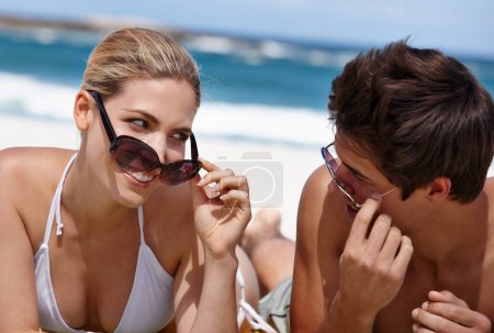 Foto de Estás más caliente que esta chica de verano. una feliz pareja joven disfrutando de un día de verano en la playa - Imagen libre de derechos