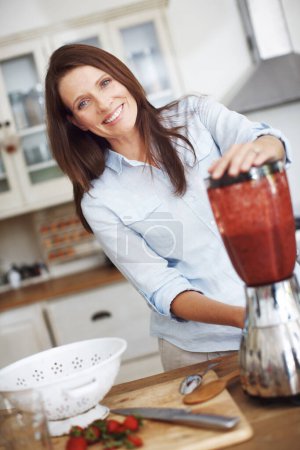 Foto de Hacer el batido perfecto. Una mujer atractiva usando una licuadora para hacer un batido de frutas - Imagen libre de derechos