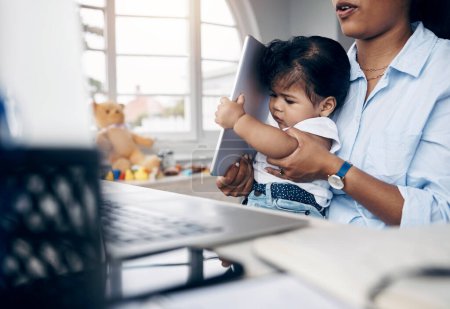 Photo for Oh, this is heavy. a young mother caring for her baby girl while working from home - Royalty Free Image