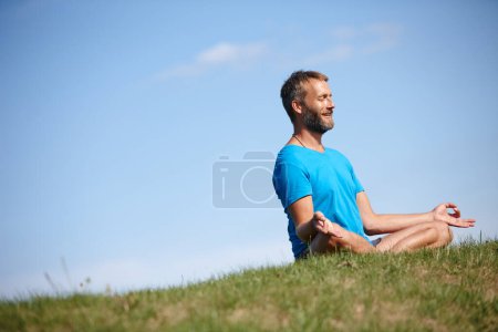 Photo for Just letting go. Full length shot of a handsome mature man meditating in the lotus position outdoors - Royalty Free Image
