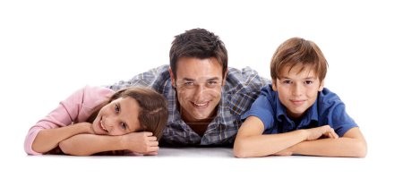 Photo for Just all chillin together. Portrait of a loving father and his children lying on their stomachs in studio - Royalty Free Image
