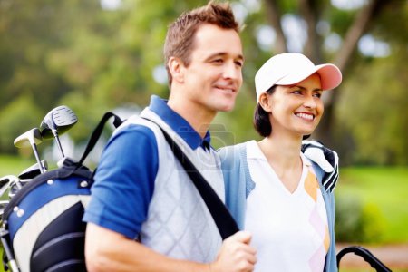 Téléchargez les photos : Joli couple de golf. Portrait de couple mignon souriant avec l'homme tenant un sac de golf - en image libre de droit