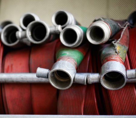 Photo for Fire hose, firefighter or fireman equipment and safety or rescue. Metal or steel tools, behind the scenes of workplace and closeup of emergency red water pipes or gear for buildings and protection. - Royalty Free Image
