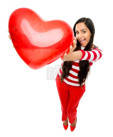 Foto de Manteniendo tu corazón en mis manos. una hermosa joven sosteniendo un globo en forma de corazón sobre un fondo de estudio - Imagen libre de derechos