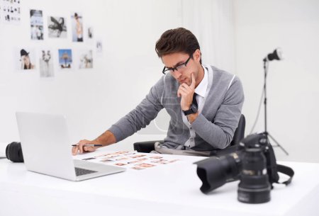 Téléchargez les photos : Montage du tournage. un jeune photographe assis à son bureau éditant des images - en image libre de droit