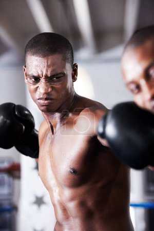Foto de Golpe de gracia. Un boxeador afroamericano dando un puñetazo en la mandíbula de sus oponentes - Imagen libre de derechos