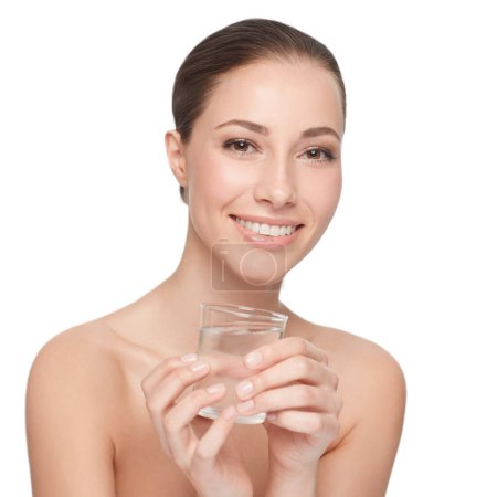 Foto de La hidratación es clave. Una hermosa mujer con hombros desnudos sosteniendo un vaso de agua - Imagen libre de derechos