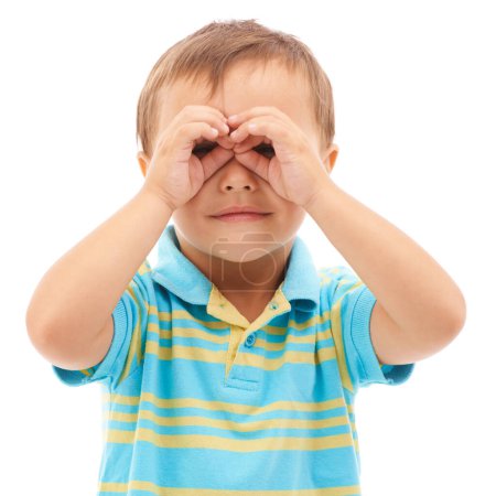 Foto de Puedo verle. Estudio de rodaje de un lindo niño mirando a la cámara a través de prismáticos de mano - Imagen libre de derechos