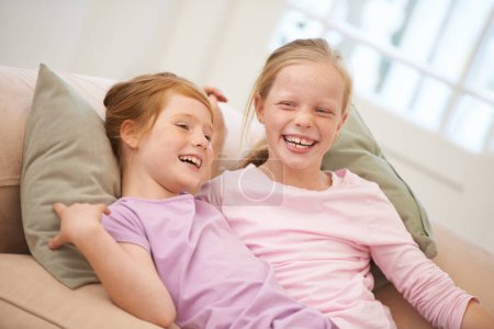 Photo for Sisters make the best friends. Portrait of two young sisters lying on the sofa at home - Royalty Free Image