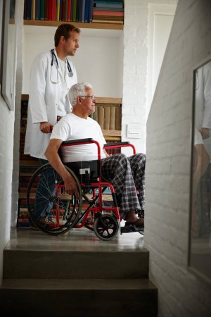 Foto de Es importante mantenerse positivo sobre la vida. un médico de pie con su paciente mayor que está en una silla de ruedas - Imagen libre de derechos