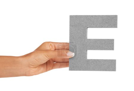Téléchargez les photos : Apprendre l'alphabet E. Une jeune femme tenant une lettre majuscule E isolée sur fond blanc - en image libre de droit