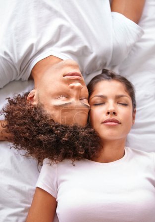 Photo for Drifting off to sleep. High angle view of an ethnic couple sleeping cheek to cheek - Royalty Free Image