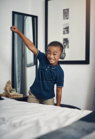 Foto de Mejorar la memoria a través de la rima, el ritmo y la melodía. un chico joven escuchando música a través de auriculares en casa - Imagen libre de derechos