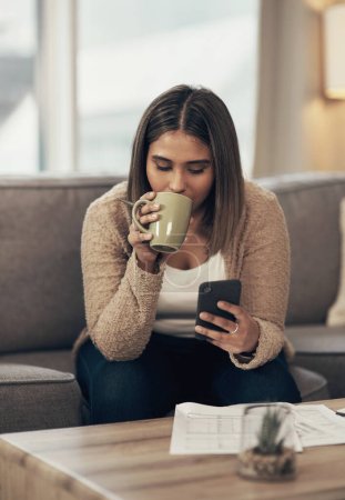 Photo for Get connected to the best budgeting apps out there. a young woman having coffee and using a smartphone while going through paperwork at home - Royalty Free Image
