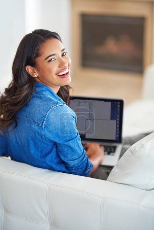 Foto de Tengo un gran contenido en mi blog. una mujer joven navegando por la web en su ordenador portátil en casa - Imagen libre de derechos