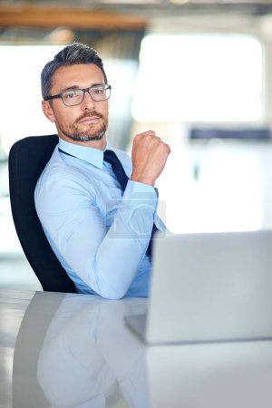 Foto de Pensando en cómo convertir sus ideas en ganancias. un hombre de negocios usando un portátil en la oficina - Imagen libre de derechos