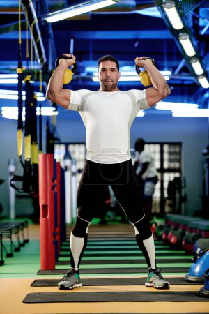 Photo for Building some serious strength. a man working out with kettle bells at the gym - Royalty Free Image