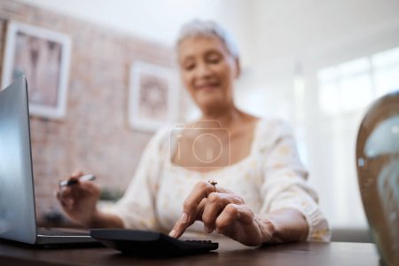 Photo for Its never too late to save for a dream. a senior woman using a laptop and calculator while going through finances at home - Royalty Free Image