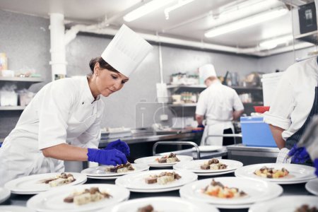 Foto de Reuniendo todos los elementos. un chef chapado de alimentos para un servicio de comidas en una cocina profesional - Imagen libre de derechos