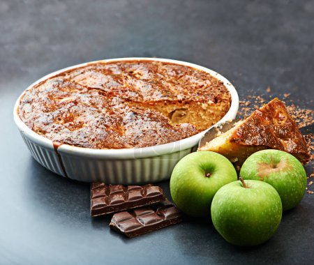Foto de Siempre se puede añadir un poco de salud a esos antojos deliciosos. tarta de manzana, manzanas y chocolate en una mesa - Imagen libre de derechos