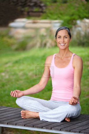 Téléchargez les photos : Évitez les médicaments et allez à la méditation. une belle femme mature pratiquant le yoga en position lotus - en image libre de droit