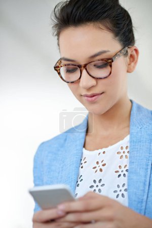 Photo for Ill be in the office today. an attractive young woman using a cellphone in an office - Royalty Free Image