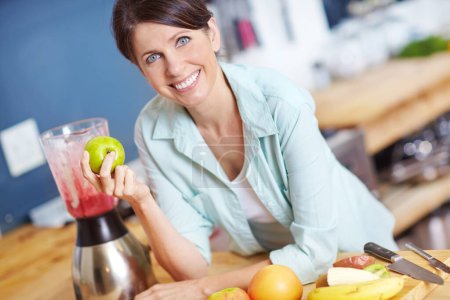 Photo for Adding all my favorite fruits to the mix. Portrait of an attractive woman making a fruit smoothie in the kitchen - Royalty Free Image