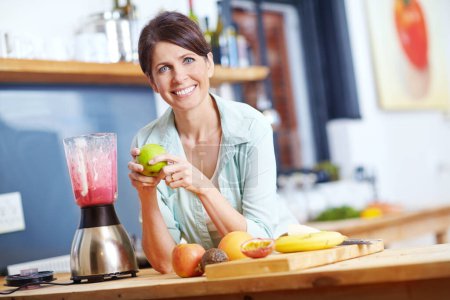 Photo for She believes in eating well. Portrait of an attractive woman making a fruit smoothie in the kitchen - Royalty Free Image