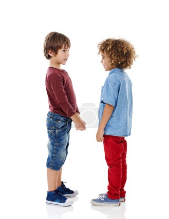Foto de Los mejores amigos. Estudio de dos lindos niños de pie cara a cara contra un fondo blanco - Imagen libre de derechos