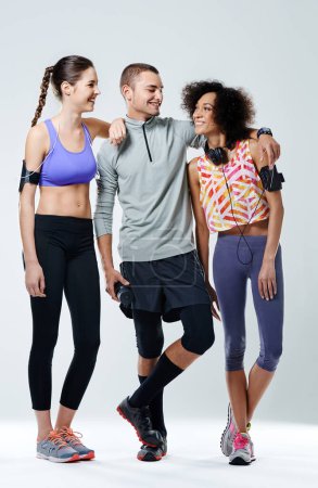 Foto de Ustedes son mi motivación. tres adultos jóvenes que visten ropa deportiva en un estudio - Imagen libre de derechos