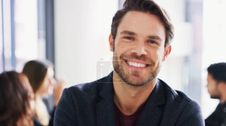 Photo for I never let anything stand in my way of success. Portrait of a young businessman sitting in an office with his colleagues in the background - Royalty Free Image