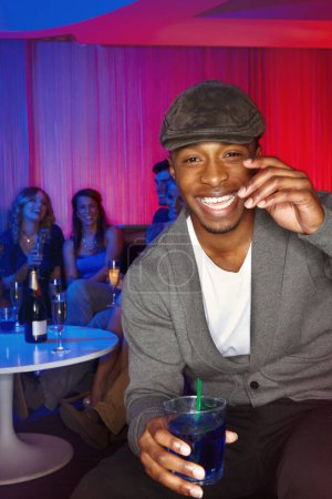 Photo for Do you come here often. A handsome young man enjoying drinks while out clubbing with his friends - Royalty Free Image