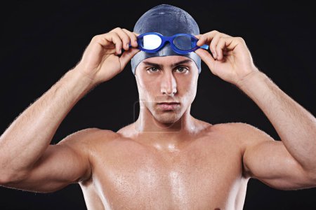 Photo for In it to win it. Studio portrait of a young male swimmer with goggles and cap - Royalty Free Image