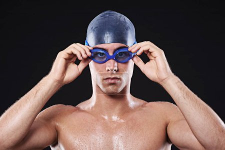 Téléchargez les photos : Sérieux pour gagner. Portrait studio d'un jeune homme nageur avec lunettes et casquette - en image libre de droit