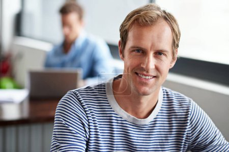Photo for Confident in my capabilities. Portrait of smiling man sitting in a casual work environment - Royalty Free Image