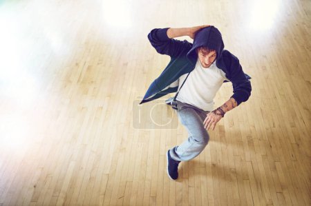 Téléchargez les photos : Briser les frontières avec son talent. Plan grand angle d'un jeune homme breakdance dans un studio - en image libre de droit