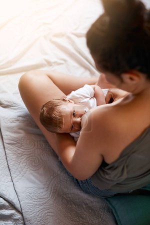 Foto de La lactancia materna tiene muchos beneficios. Foto de ángulo alto de una madre joven amamantando a su bebé recién nacido en casa - Imagen libre de derechos