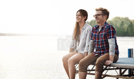 Photo for The perfect spot for some romance. a happy young couple sitting on a pier - Royalty Free Image