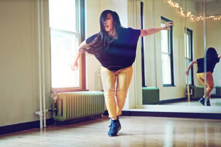 Téléchargez les photos : Faites compter chaque mouvement. une jeune femme dansant dans un studio - en image libre de droit