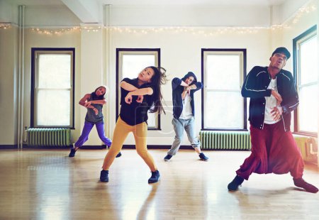 Téléchargez les photos : Prendre le contrôle de l'industrie de la danse avec leur talent. un groupe de jeunes dansant ensemble dans un studio - en image libre de droit