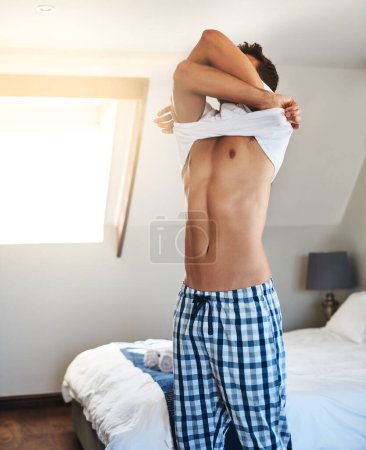 Foto de Hora de empezar el día. un joven guapo preparándose para el día en su habitación en casa - Imagen libre de derechos