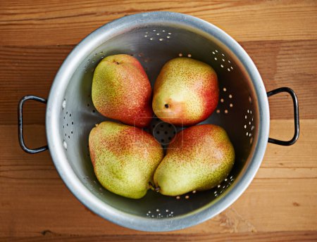 Photo for Looking sweet and juicy. a bowl of pears on a kitchen table - Royalty Free Image