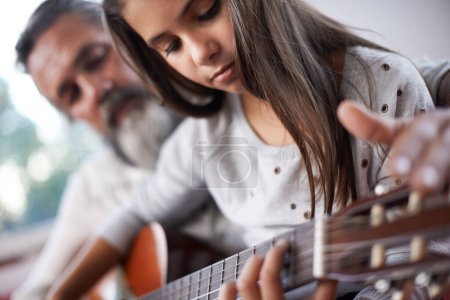 Téléchargez les photos : Fille apprendre à jouer de la guitare, grand-père enseigner à l'enfant avec l'éducation musicale et aider à la créativité. Musicien, art et homme mûr aidant les jeunes filles à apprendre la concentration et les compétences sur l'instrument de musique. - en image libre de droit