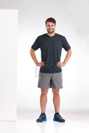 Photo for Happy to be healthy. Studio shot of a smiling young man standing casually with his hands on his hips - Royalty Free Image