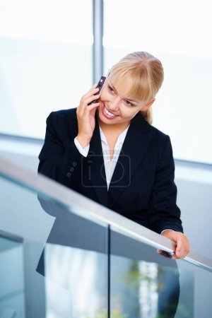 Téléchargez les photos : Femme d'affaires parlant sur téléphone portable. Belle femme d'affaires debout près des escaliers et utilisant un téléphone portable - en image libre de droit