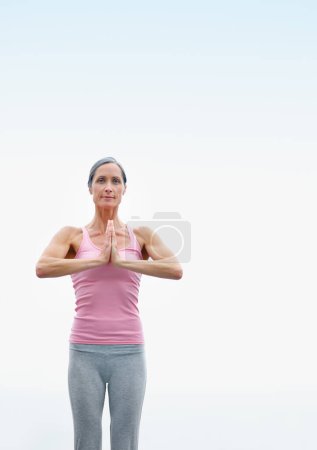 Foto de Encontrar la paz y la calma en un mundo ocupado. una atractiva mujer madura haciendo yoga al aire libre - Imagen libre de derechos